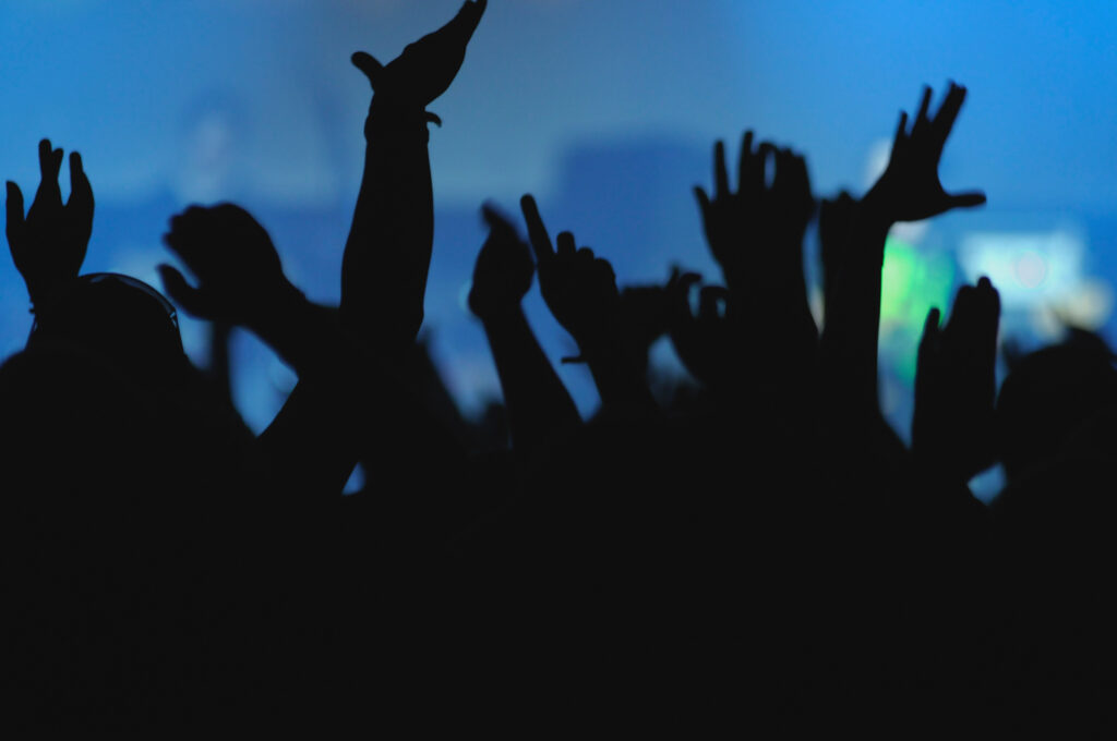 Crop hands of anonymous people having fun on magnificent music show